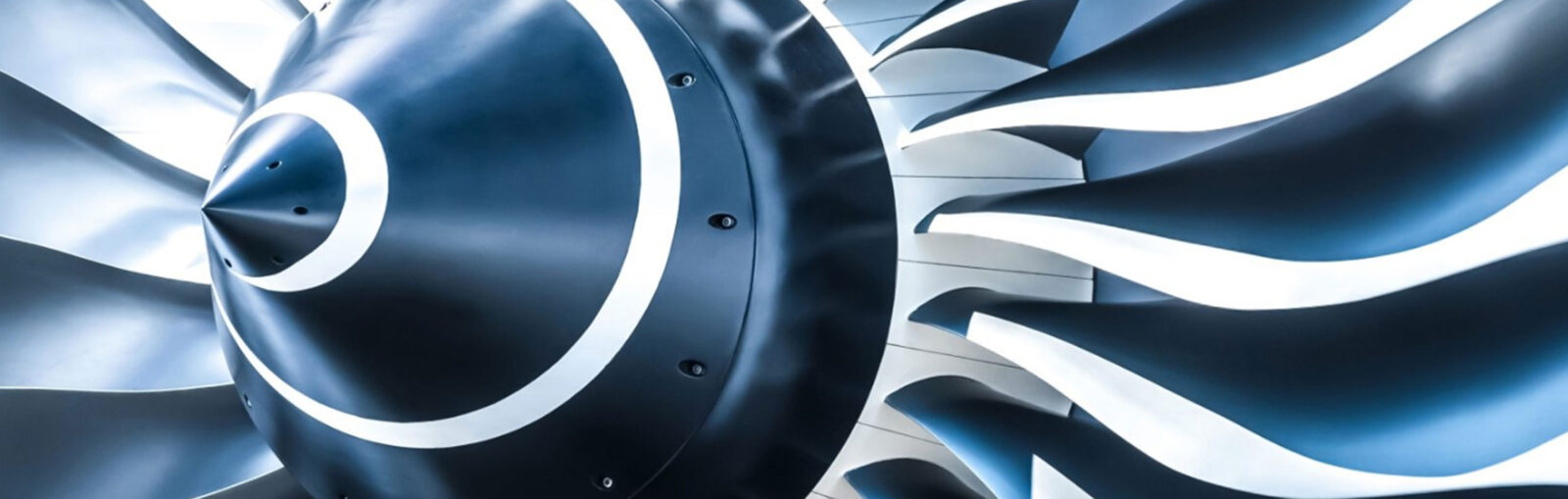 Close-up of a jet engine turbine with blades, showcasing aircraft engine technology.